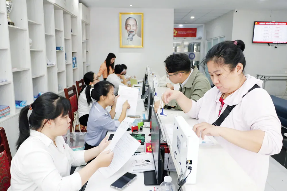 Công chức Trung tâm Phục vụ hành chính công phường Bến Thành (TPHCM) giải quyết hồ sơ cho người dân. Ảnh: NGÔ BÌNH Screenshot 2025-09-02 080445.png