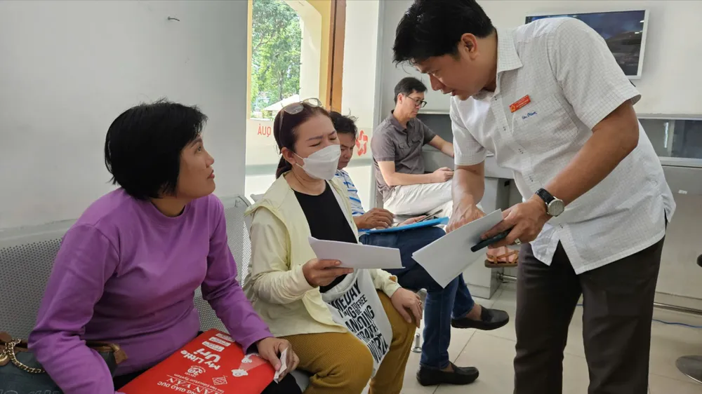 Công chức TPHCM hướng dẫn giải quyết hồ sơ cho người dân. Ảnh minh họa z6959271924680_42d6334e4006c53ab7e2831764b8f5fa.jpg