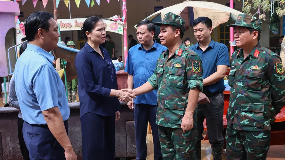 Bà Hà Thị Nga, Phó Chủ tịch Ủy ban Trung ương MTTQ Việt Nam động viên lực lượng vũ trang đang hỗ trợ nhân dân vùng lũ