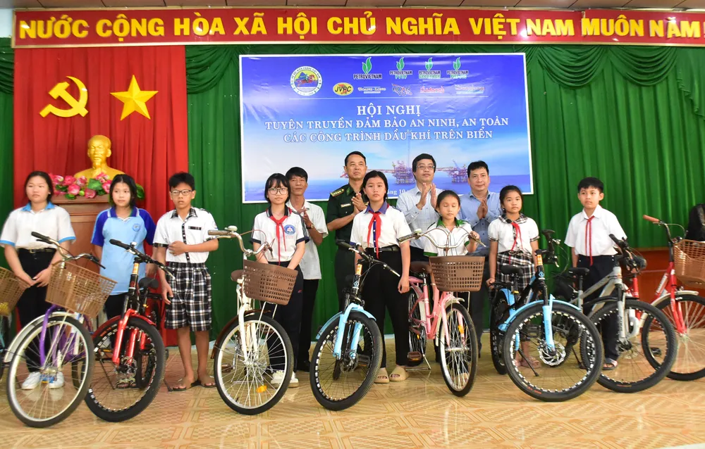 Đại tá Doãn Đình Tránh, Phó Chính ủy Ban Chỉ huy Bộ đội Biên phòng tỉnh An Giang và ông Lê Quang Ánh, Trưởng Phòng an toàn - Tổng Công ty Thăm dò Khai thác Dầu khí (PVEP) trao tặng xe đạp đến các học sinh là con của ngư dân có hoàn cảnh khó khăn. Ảnh: NAM KHÔI DSC_0460.jpg