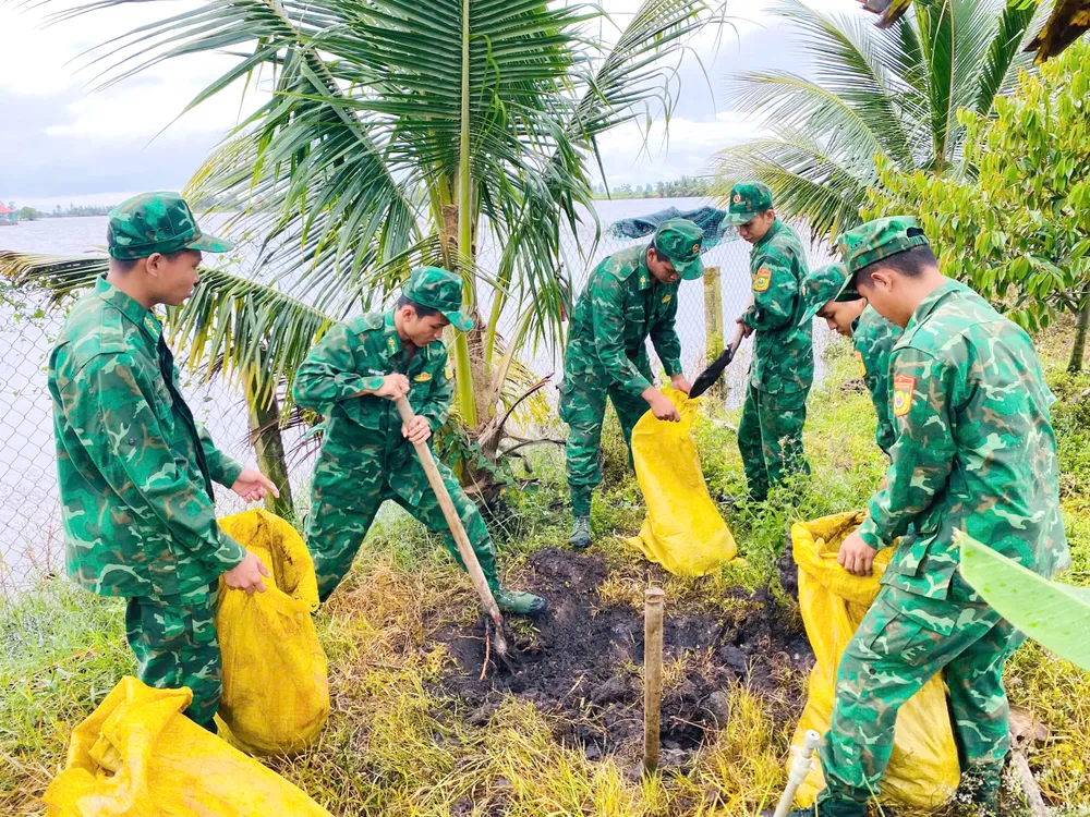 Chiến sĩ Đồn Biên phòng Vĩnh Gia hỗ trợ nhân dân đắp đê chống ngập vườn cây ăn trái vào sáng 29-10 67fc093e1e9393cdca829.jpg