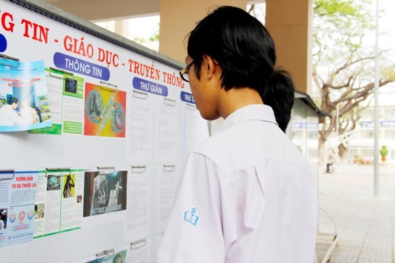 Students read poster of tobacco harm (Photo: SGGP)