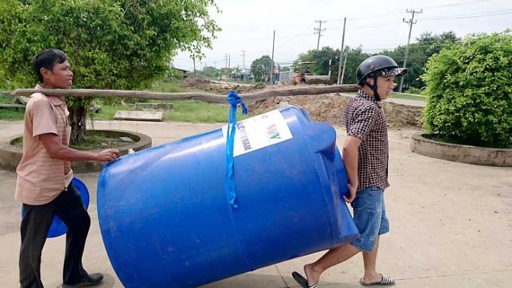 Poor people receive water containers (Photo: SGGP)