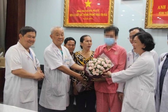 Doctors of Cho Ray present flower to the man on the day he is discharged (Photo: SGGP)