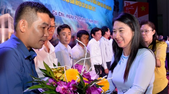 A representative of Cu Chi goverment presents flower to fund contributors at the event (Photo: SGGP)