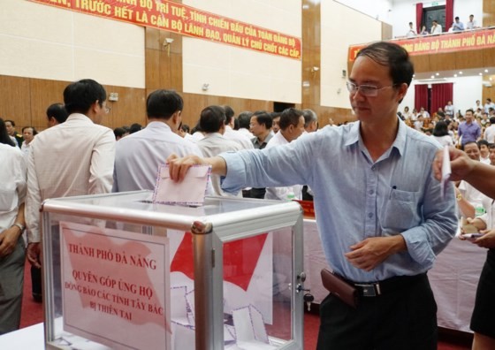 Employees and party members give their one-day salary to support locals in flood-hit areas (Photo: SGGP)