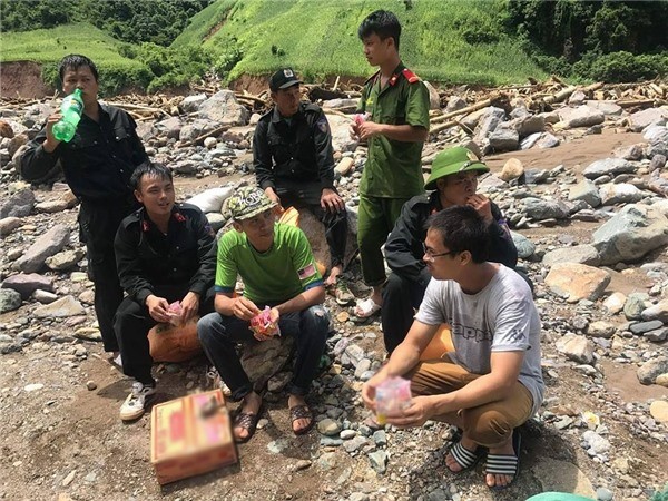 Soldiers and volunteers make a quick meal of instant noodles before continuing their work to carry food and other necessities to flood-hit residents in Yen Bai Province. — Photo thethaovanhoa.vn