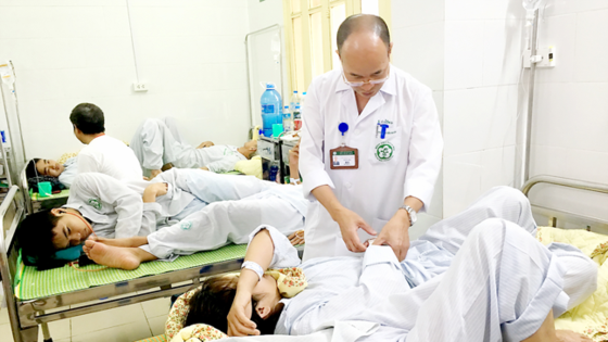 A doctor forgets to wear mask and glove when examining patients (Photo: SGGP)