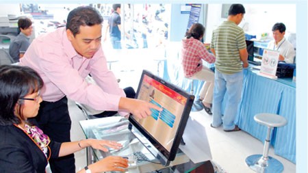 Officers of the People’s Committee of Ben Thanh Ward (District 1, Ho Chi Minh City) are helping citizens to use their fingerprint to check information and register for civil-status-related, real-estate-related, and copy-certifying-related activities (Phot