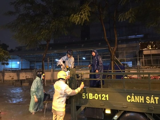 Traffic police help people to move through deep inundated streets (Photo: SGGP)