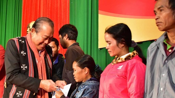 Deputy Prime Minister Truogn Hoa Binh gives gifts to poor people in A Luoi District (Photo: SGGP)