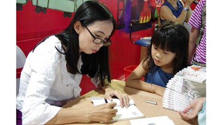 Author Vo Dieu Thanh in a book signing session in the Second Can Tho Book Fair. Photo by Van Thanh Le.