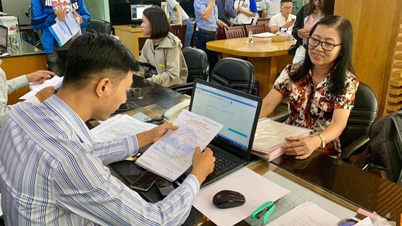 63-year-old Dao Thi Thu ( R) at Van Hien University's office to register at piano and French classes (Photo: SGGP)