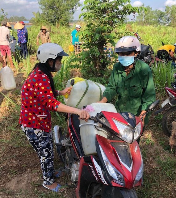 Residents carry plastic containers to take water home (Photo:SGGP)