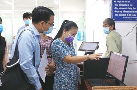 Citizens are learning about online public services at the People’s Committee of Hoc Mon District. (Photo: SGGP)