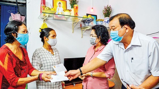 Director of the municipal Department of Labor, Invalid and Social Affairs Le Minh Tan gives money to lottery ticket vendors (Photo: SGGP)