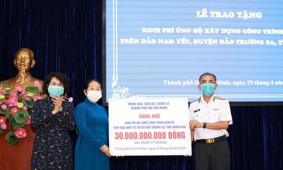 Deputy Secretary of the municipal Party Committee Vo Thi Dung gives support money to Deputy Commander of the Vietnam People's Navy Rear Admiral Luong Viet Hung (Photo: SGGP)