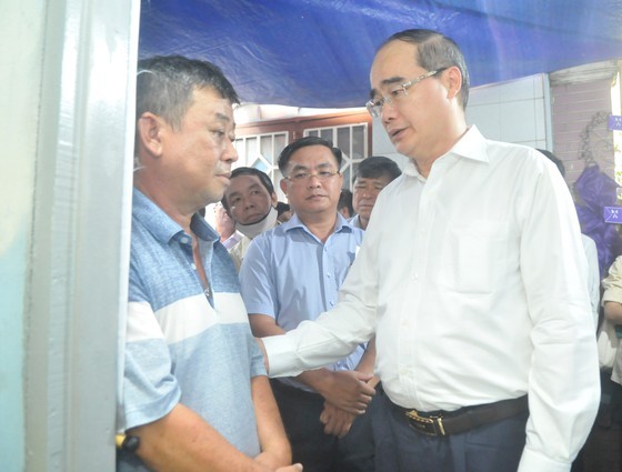 Secretary of the Ho Chi Minh City People’s Committee Nguyen Thien Nhan (1st, R) expresses his condolence to the bereaved father (Photo: SGGP)