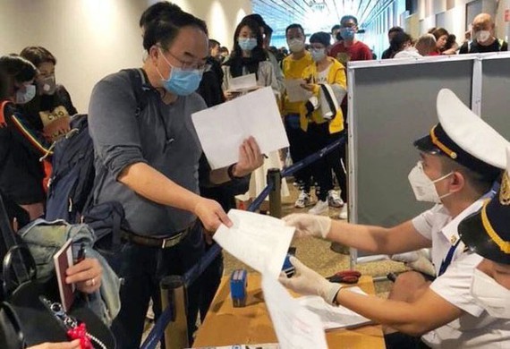 People from oversea write mandatory health declarations at Tan Son Nhat Airport (Photo: SGGP)