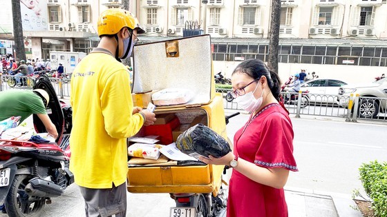 An online buyer receives goods from a shipper in District 3 (Photo: SGGP)