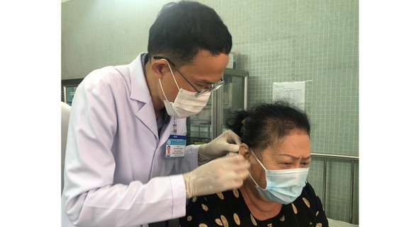 A doctor uses traditional medicine to treat a patient (Photo: SGGP)