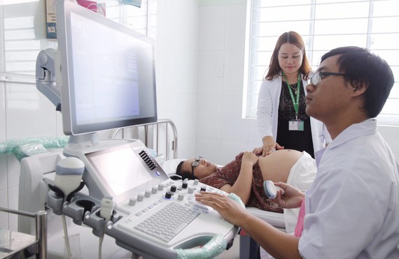 A doctor is examining a pregnant woman (Photo: SGGP)