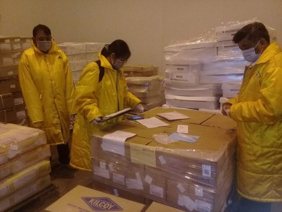Inspectors check imported frozen food (Photo: SGGP)