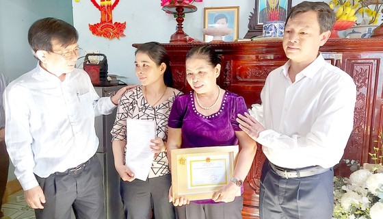 Pham Thi Mai ( purple) receives the medal (Photo: SGGP)