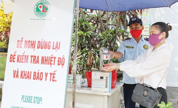 People are instructed to wash their hands with disinfectant before entering patients' rooms (Photo: SGGP)