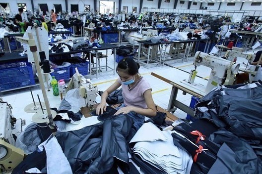Vietnamese workers make clothing products for export. (Photo: VNA)