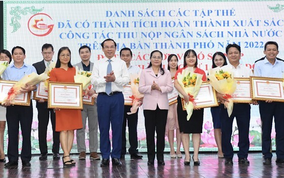 Secretary of the City Party Committee of Ho Chi Minh City Nguyen Van Nen and Chairwoman of the People&apos;s Council of Ho Chi Minh City Nguyen Thi Le presented certificates of merit to collectives with outstanding achievements in budget collection and payment (Photo: SGGP)