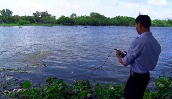 A staff from the Southern Institute of Water Resources Research is checking the salinity in the river A staff from the Southern Institute of Water Resources Research is checking the salinity in the river