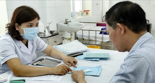 A medical worker gives advice to a resident in Hanoi. (Photo: VNA)