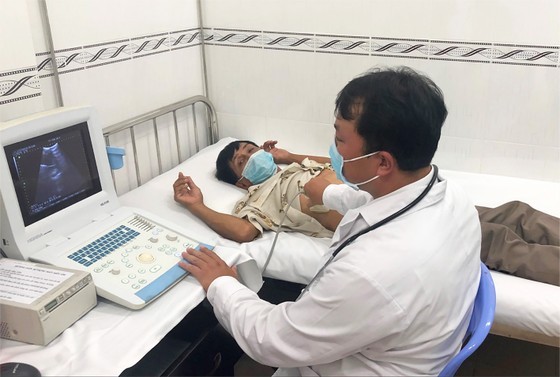 A doctor is examining a patient in Vinh Loc A in Binh Chanh outlying district
