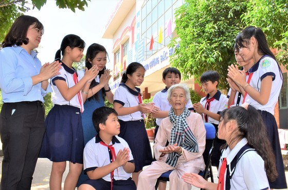 Vietnamese Heroic Mother Kieu Thi Nong and children in a local school in Cu Chi District, HCMC