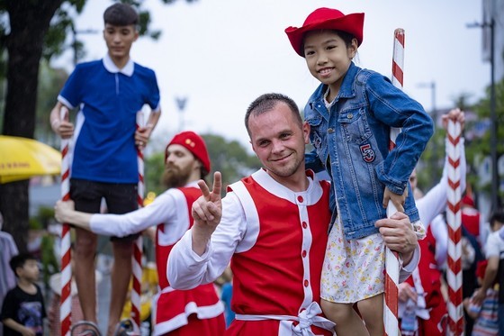 Belgian artists instruct children to walk on tall sticks Belgian artists instruct children to walk on tall sticks
