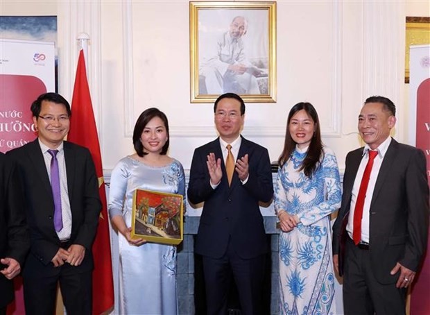 State President Vo Van Thuong (center) presents a gift to the Association of Overseas Vietnamese in the UK (Photo: VNA)