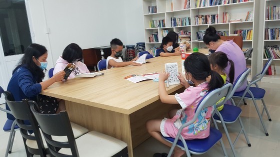 Residents in a residential quarter in HCMC's District 7 read books at a community bookcases Residents in a residential quarter in HCMC's District 7 read books at a community bookcases