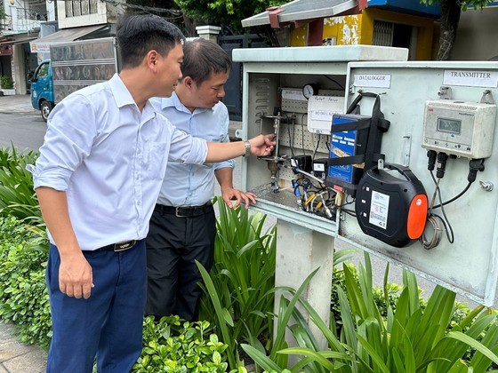 Mr. Nguyen Trong Nhan, an employee of Phu Hoa Tan Water Supply Company instructs a colleague on the operations at the DMA signal cabinet. (Photo: SGGP)