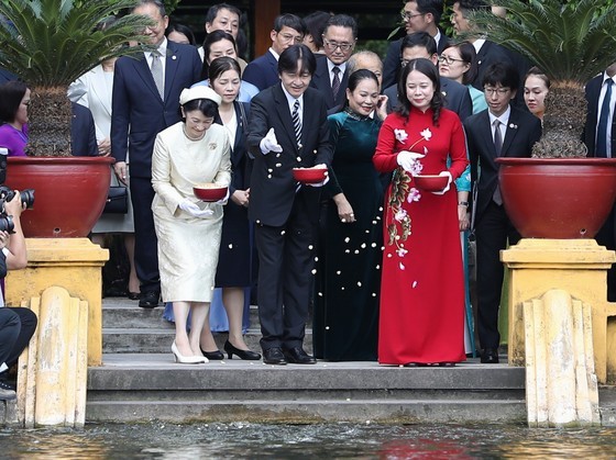Vice President Vo Thi Anh Xuan and Japanese Crown Prince Akishino, Princess Kiko feed fish in a pond in the gardens of the presidential palace. (Photo: SGGP)