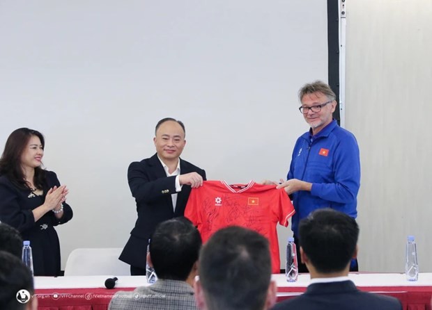 Head coach Philippe Troussier (R) presents a jersey with Vietnamese players' signatures to the Vietnamese Embassy in Qatar on January 12. (Photo: Vietnam Football Federation) embassyofferssupporttovietnameseplayersatasiancupfinals-6505.jpg