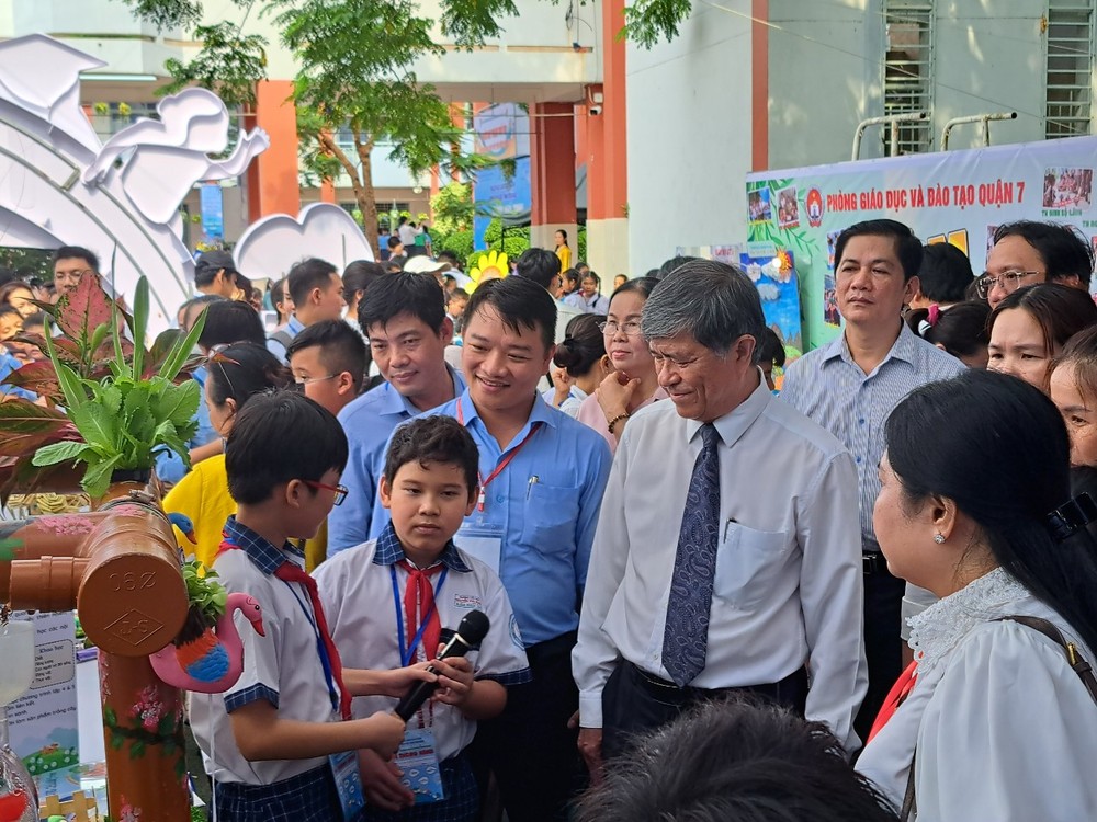Director of Ho Chi Minh City Department of Education and Training Nguyen Van Hieu (white shirt, tie) listens to students introducing their products at the festival edu.jpg