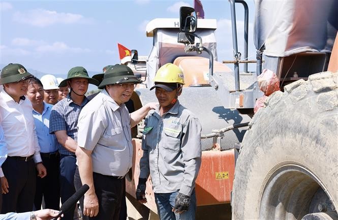 PM Pham Minh Chinh talks to a worker at the construction site of the Van Phong - Nha Trang expressway project on April 29. (Photo: VNA) prime_minister_examines_expressway_projects_in_central_region.jpg