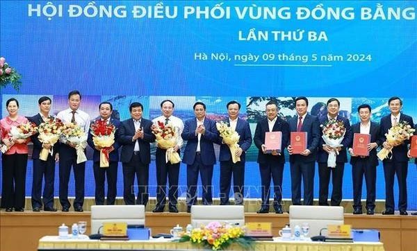 Prime Minister Pham Minh Chinh (middle) hands over to leaders of localities the decisions approving planning of cities and provinces in the Red River Delta region (Photo: VNA) vna-potal-thu-tuong-chu-tri-hoi-nghi-lan-thu-ba-hoi-dong-dieu-phoi-vung-dong-bang-song-hong-stand-1058.jpg.webp