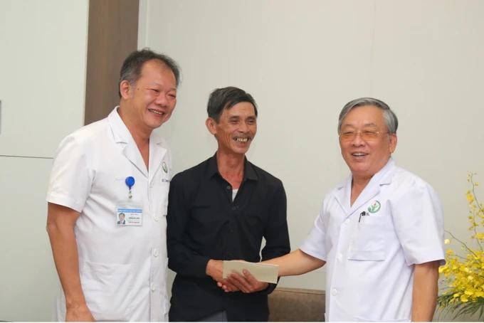 Patient Tran Ngoc Thanh (C) shows his sincere gratitude to Associate Professor Nguyen Tien Quyet (R) and Dr. Duong Duc Hung (L) ghep-gan.webp