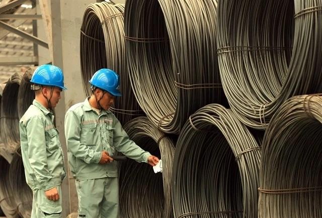 Technicians check rolled steel at the factory of the Vietnam Steel Corporation (VNSTEEL). (Photo: VNA) tax.webp