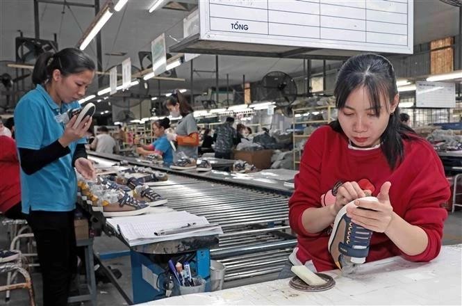 Workers of Ha Tay Chemical Textile Co., Ltd produce shoes for export. (Photo: VNA) footwear.jpg