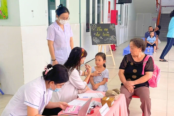 Medical workers examine a child at a preschool in HCMC image005-8136.png