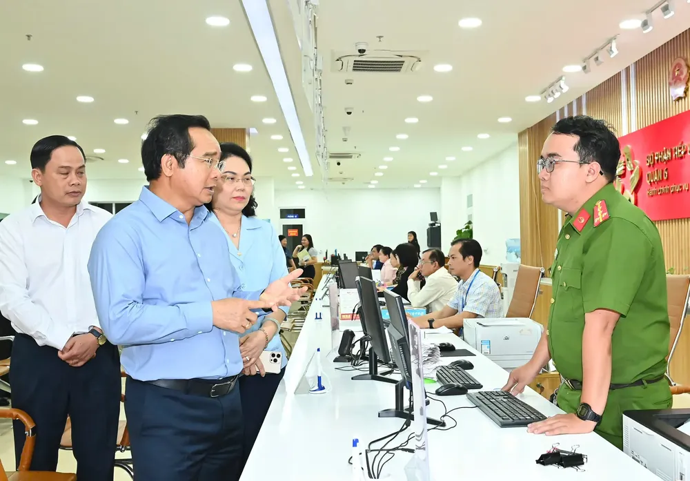 Chairman of Ho Chi Minh City People's Committee Nguyen Van Duoc talks with police officers on duty at the Division of Issuing and Returning ID Cards. z6743527818247-7f5c67fd1b18ee713956373bc8cfec6c-1406-5422.jpg