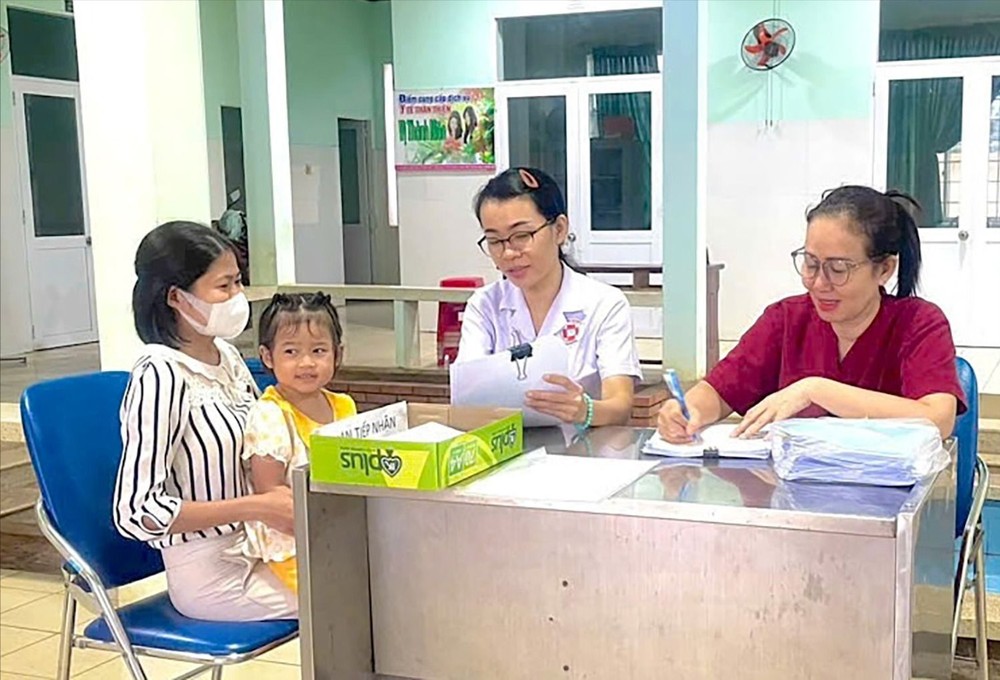 Dr. Luu Thi Ngoc Hang, Head of Tam Long Ward Health Station (second from right), consults with a child patient's family member. c3b-4444-1618.jpg.jpg